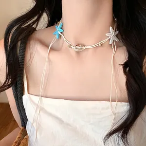 Detail of summer beach choker with natural shell and starfish charms on a layered cord