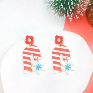 Close-up of handmade Christmas earrings with snowman and festive patterns on white background