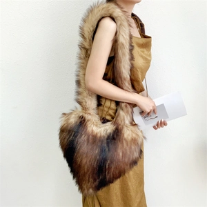 Detail view of heart-shaped faux raccoon fur crossbody bag with brown gradient plush texture