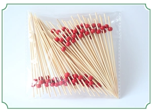 Bamboo fruit picks with red wooden beads in transparent pack on white background