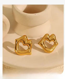 Macro detail of 18k gold plated stainless steel lip-shaped earrings with heart cutout
