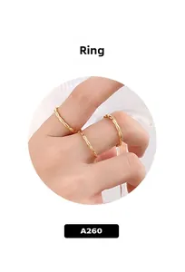 Vue détaillée de trois bagues dorées minimalistes à texture bambou sur une main
