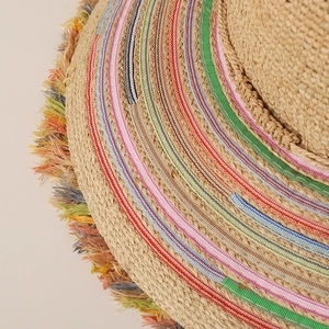 Detail of raffia sun hat with colorful rainbow crochet trim and boho fringe edges