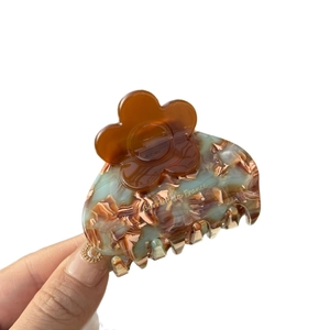 Floral acetate hair claw clip with marble texture and golden metal chain detail