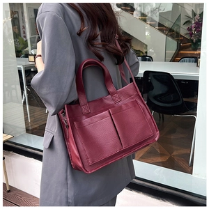 Detailed view of burgundy PU leather tote bag with front pockets and top handle