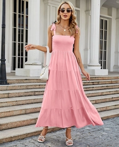Détail de la robe longue rose à plusieurs niveaux avec bretelles à nœuds et buste froncé