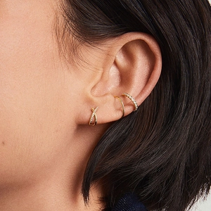 S925 sterling silver crisscross stud earrings with sparkling diamonds on a model's ear