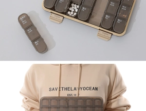 Detail view of 21 compartments pill organizer showing AM PM sections and hand-held size