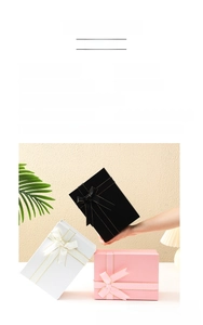 Detail of foldable gift boxes in black, pink, and white with elegant decorative bow ribbons