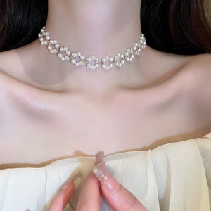 Close-up of French vintage pearl flower choker necklace with elegant gold accents