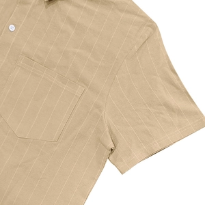 Close-up of khaki linen short sleeve shirt featuring white stripes and front pocket detail