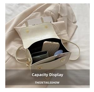 Internal capacity of beige leather crossbody bag showing main compartment and front pocket