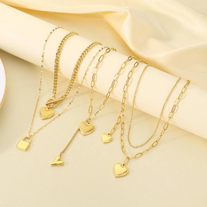 Double-layered gold stainless steel heart and star pendant necklace on beige silk