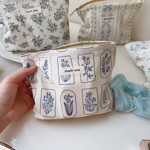 Close-up of floral cotton makeup bag with blue botanical print and zipper detail