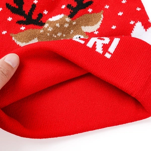 Détail du bonnet de Noël tricoté rouge épais avec des motifs de rennes en gros plan