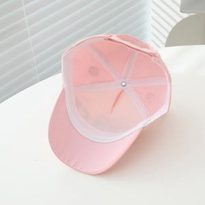Detail of pink cotton baseball cap interior showing six-panel structure and sweatband
