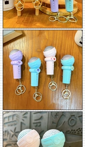 Detail view of colorful mini microphone keychains with metallic mesh heads and clips.