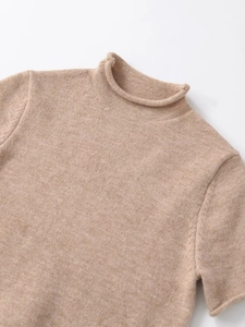 Close-up of mock neck and fine knit texture on a light coffee short sleeve sweater