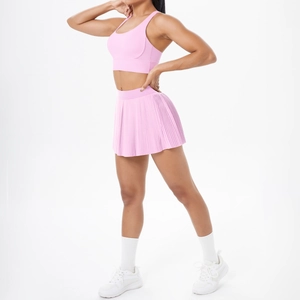 Détail de la brassière de sport rose et de la jupe plissée en tissu élastique