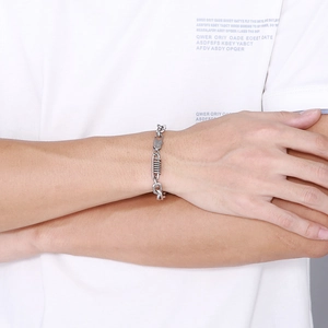 Detail view of silver stainless steel curb chain bracelet with spring ring clasp on wrist