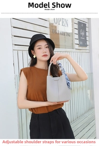 Detail of light gray lychee leather bucket bag with silk scarf on the handle
