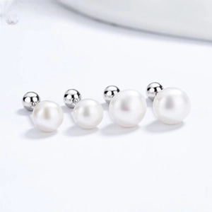 Detailed view of white shell pearl earrings with minimalist silver ball screw back design