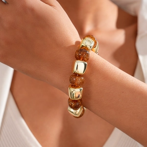 Detailed shot of retro amber beads and gold square metal spacers on a stretch bracelet
