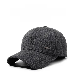 Detail of grey wool baseball cap with ear flaps and metallic emblem for winter