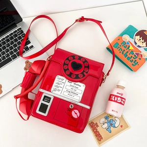 Macro shot of red retro telephone crossbody bag with dialer and coin return details