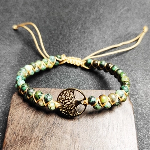 Close-up of African turquoise beads and Tree of Life charm on braided yoga bracelet