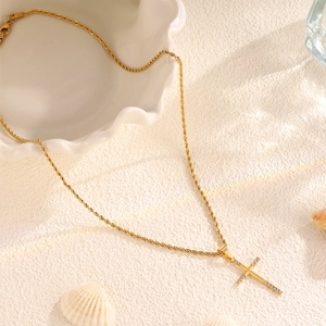Close-up of a gold-plated stainless steel cross necklace with crystal pavé on rope chain
