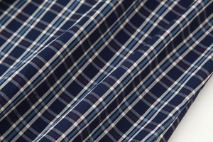Makro-Detail von rot-blauem Karostoff aus Baumwolle mit feiner Webstruktur für Kleider
