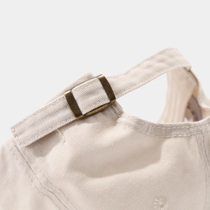 Detail of adjustable brass metal buckle and high-quality twill cotton fabric on beige cap