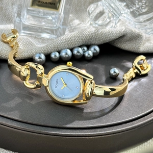 Detailed macro shot of the light blue dial with rhinestone markers and gold-tone horseshoe case
