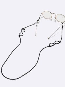 Detail of black metal glasses chain with miniature eyewear charms and silicone loops