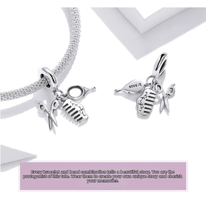 Macro detail of S925 sterling silver hair stylist charms with scissors and comb