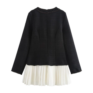 Dettaglio del corpino in tweed nero e dell'orlo a pieghe bianco su un abito elegante