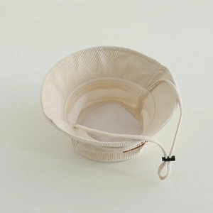 Close-up of cream-colored bucket hat interior featuring adjustable white windproof drawstring