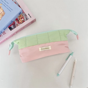 Macro detail of quilted color-block pencil case with Sozakka tag and green zipper