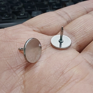 Macro shot of silver metal butterfly clutch pin backs held in hand for DIY jewelry