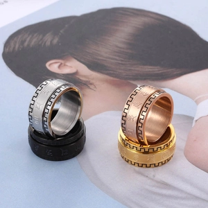 Macro detail of rotating stainless steel rings with embossed mantra in four metal finishes