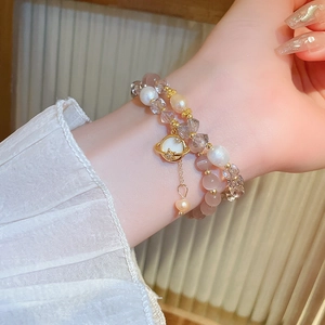 Détail du bracelet double couche en pierre œil de chat, perles et pendentif planète doré