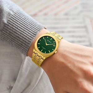 Close-up of CURREN gold square watch with green dial worn on a model's wrist
