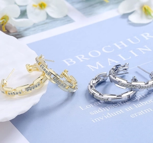 Close-up of gold and silver chain hoop earrings with micro-pave white zircon stones