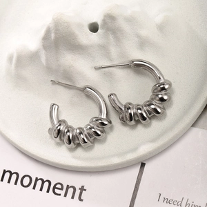 Macro detail of silver stainless steel hoop earrings with a unique twisted spiral design