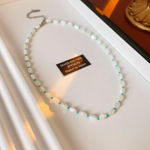 Macro shot of 925 silver shell and aquamarine beaded necklace with elegant closure detail