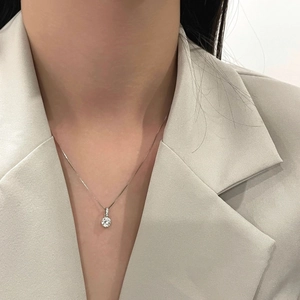 Elegant minimalist necklace with a round silver cubic zirconia pendant worn by a model