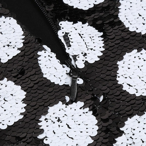 Macro view of black and white sequins texture with a center zipper closure detail