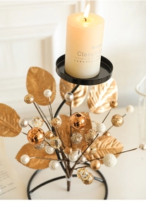 Close-up of iron Christmas candle holder with golden leaves and elegant decorative balls