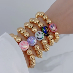Detail of 18k gold plated beaded bracelets featuring five colorful smiley face charms